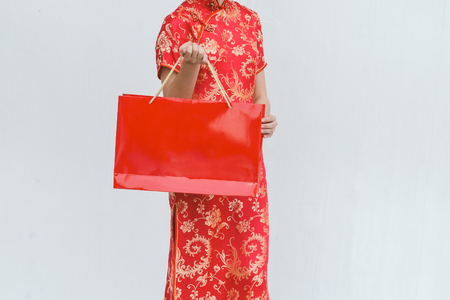 Asian woman holding shopping bag, woman wear cheongsam, chinese new yearの写真素材