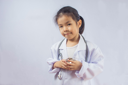 Asian girl playing as a doctor care money in cupの写真素材