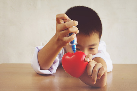 Asian boy playing as a doctor care healthy heartの写真素材