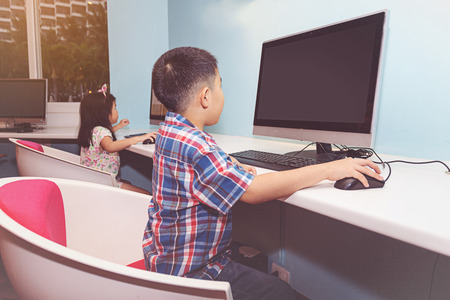 Boy and Girl playing with a computer