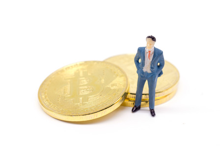 Toy businessman and Bitcoin on white backgroundの写真素材