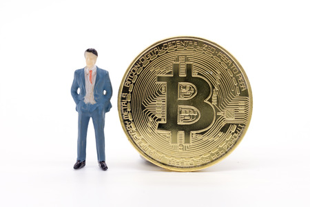 Miniature businessman and Bitcoin on white backgroundの写真素材