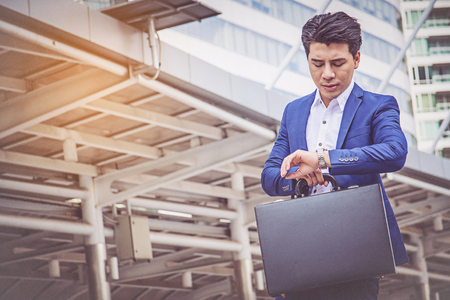 Young businessman checking the time on her watch.の写真素材