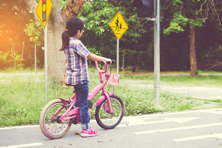 girl is cycling in the park, bicycle stops at traffic lightsの写真素材