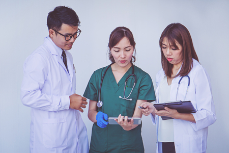 doctor and nurse checking patient information on a tablet deviceの写真素材