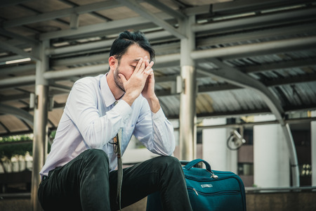 Young depressed businessman sitting on the stairsの写真素材
