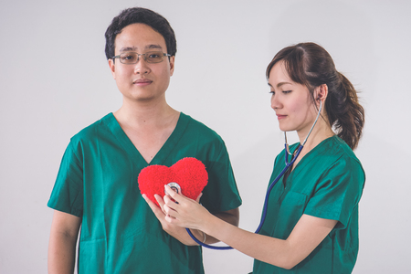 doctor with stethoscope examining red heartの写真素材
