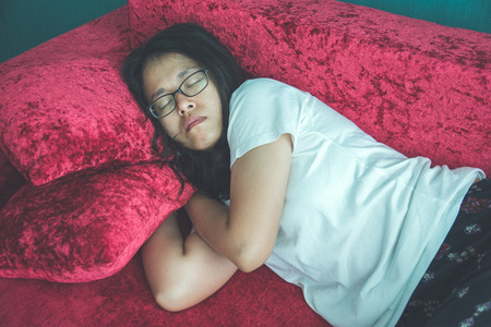 young woman sleeping on sofa at homeの写真素材