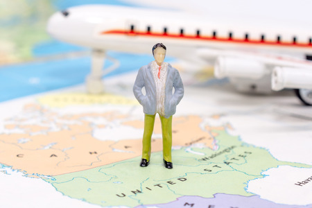 Miniature people, businessman standing on map Americanの写真素材