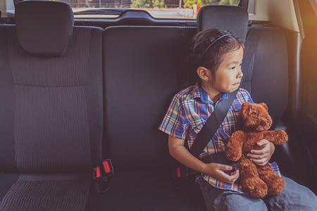 happy little girl wearing seatbelts in carの写真素材