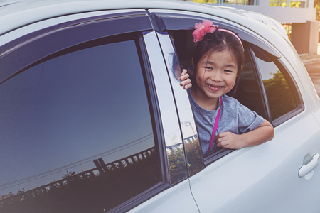 Little girl looking through window.の写真素材
