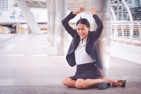 Young depressed businesswoman sitting on the floorの写真素材