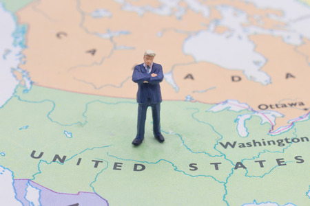 Miniature people, businessman standing on map Americanの写真素材