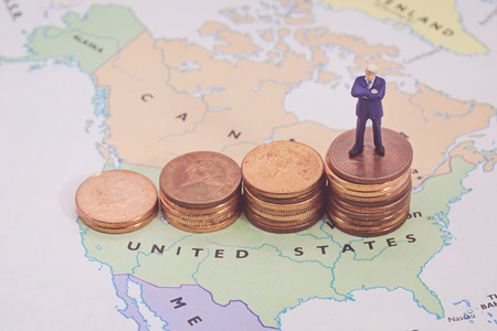 Miniature people, businessman standing on map American