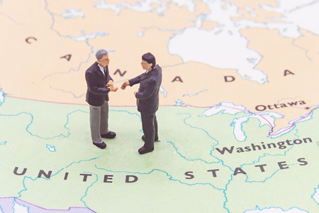 Miniature people, businessman standing on map Americanの写真素材