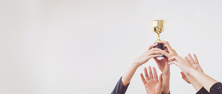 Hands scramble for the golden trophy cup, concept businessの写真素材