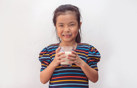 Cute little girl with glass of milkの写真素材