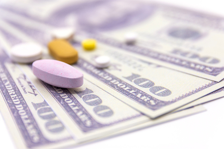 dollar bank and medicine capsules on white background. healthy lifestyle with business finance conceptの写真素材