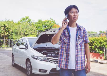 Asia man stand front a broken car calling for assistanceの写真素材