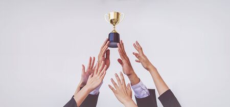 Hands scramble for the golden trophy cup, concept businessの写真素材