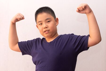 Asia boy wearing t-shirt shows how strong and powerの写真素材