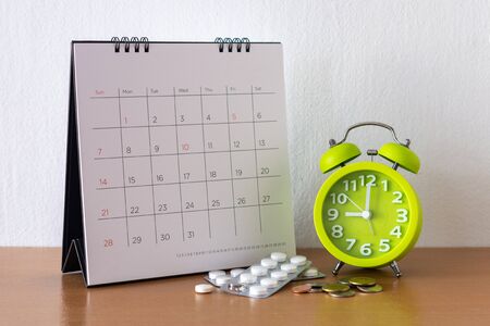 Calendar and drugs on table. 