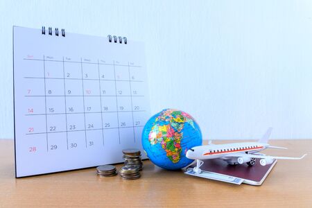 Airplane model with paper calendar on wooden table. plan for tripの写真素材