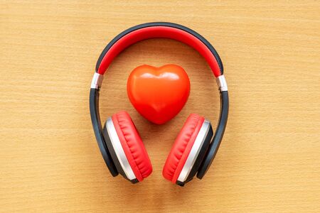 Headphones and red heart on wooden desk. Musical conceptの写真素材