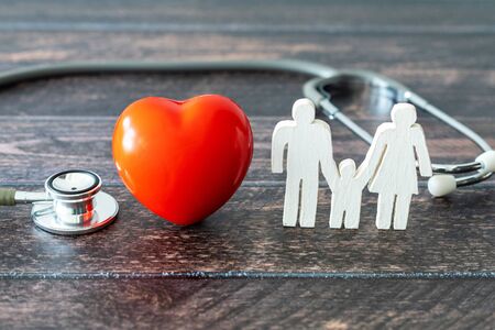 Red heart, stethoscope and icon family on wooden desk. Medical Insurance Concept の写真素材