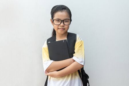 Asian girl elementary school with book and bag. Back to school. education conceptの写真素材