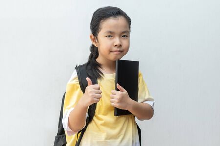 Asian girl elementary school with book and bag. Back to school. education conceptの写真素材