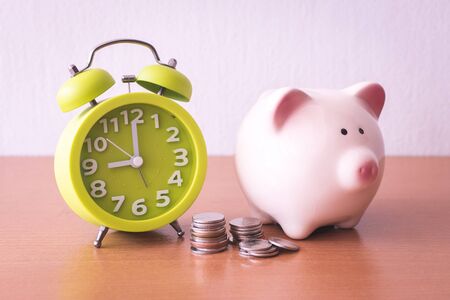 Piggy bank, alarm clock and coins. for growing business. time to saving concept.の写真素材