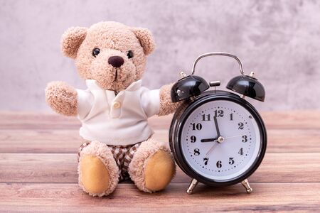 teddy bear and clock on table wooden. Valentine's Day celebrationの写真素材