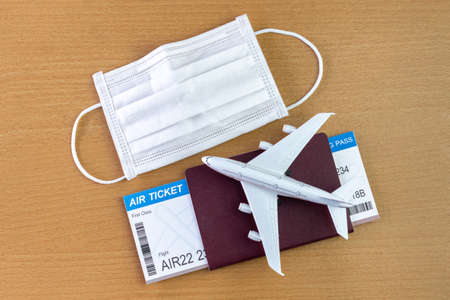 Travel during the covid-19 pandemic. airplane model with face mask, air ticket and passport. ready for holidays.の写真素材
