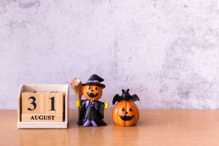 Wooden calendar block disrupted show date 31 october halloween day and toy pumpkin on wooden background. Halloween conceptの写真素材