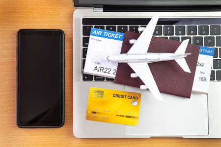 Smartphone near laptop computer and airplane on table. Online ticket booking conceptの写真素材