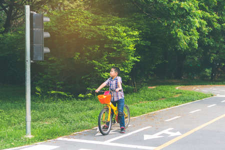 boy is cycling in the park, bicycle stops at traffic lightsの写真素材