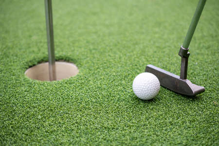 Golf ball and golf club on artificial grass.の写真素材