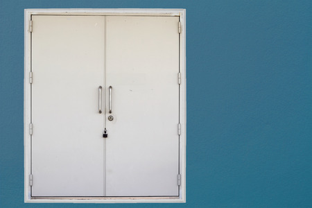 Closed door on blue wall backgroundの写真素材