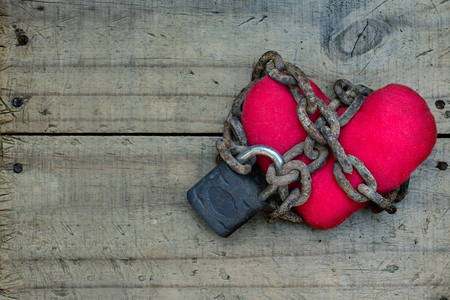 Red heart tied with rusty chain and lock. Love concept-Retro style.の写真素材