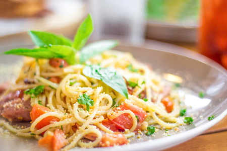 Spaghetti in olive oil with sausage,tomato and basil leaf.Selective focus.の写真素材