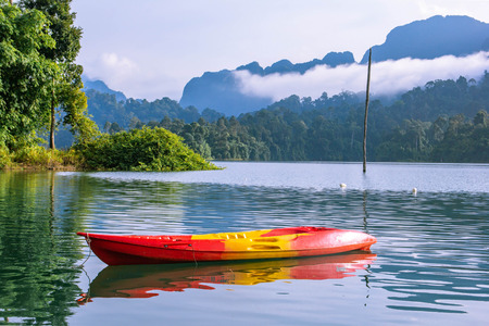 Yellow orange canoe or kayak with mountain lake viewの写真素材