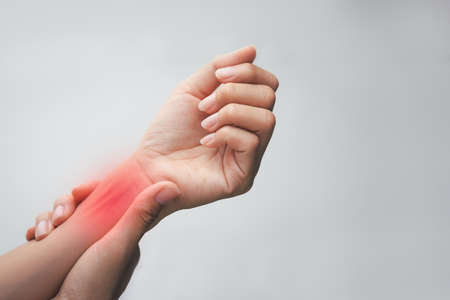 Woman holding her wrist to spot  of wrist painful. Neurological disease - Healthcare and medical concept.の写真素材