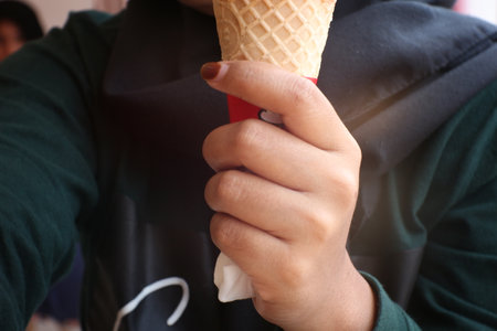Ice cream cone in the hand of a child, close-upの写真素材