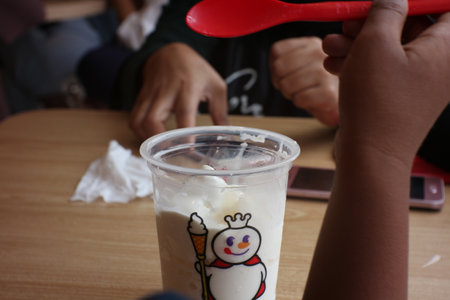 snowman and ice cream in a plastic cup on the tableの写真素材