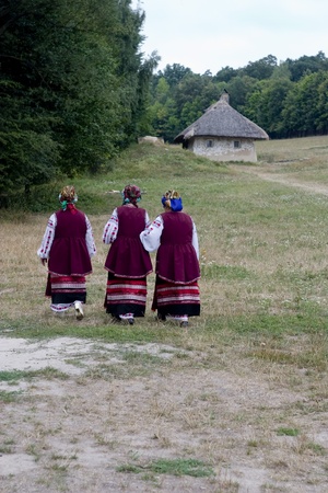 womans in the ukrainian national dress against a forest, road and hutsのeditorial素材