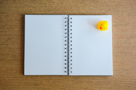 notebook and yellow duck on wood deskの写真素材
