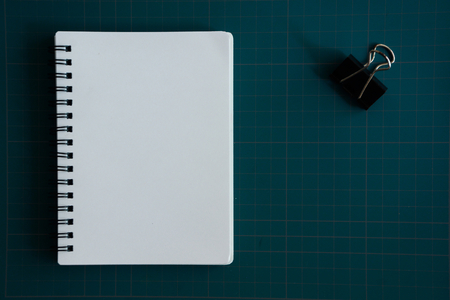 Notebook and paper clip on cutting boardの写真素材