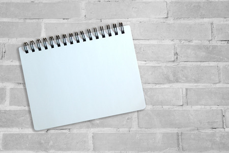 White page of notebook on gray brick wallの写真素材