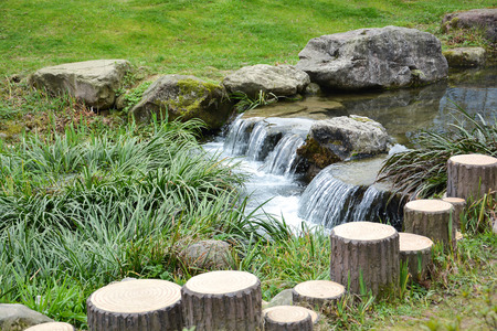 Small waterfall over rocks in Chinese gardenの写真素材